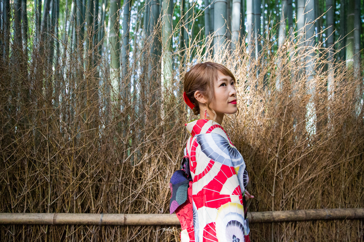 竹の道を背景に着物を着た女性のポートレート写真。