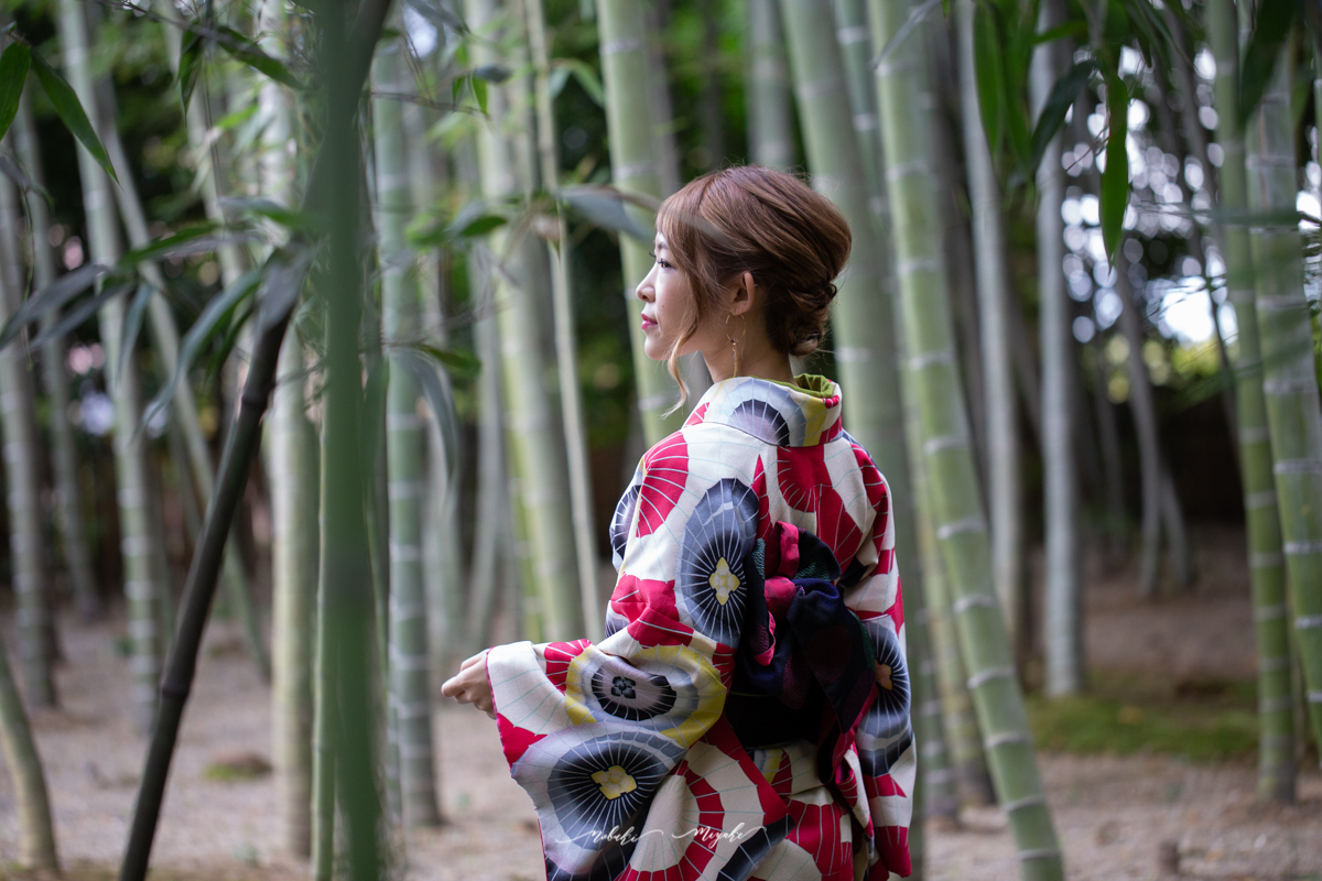竹の道を背景に着物を着た女性のポートレート写真。