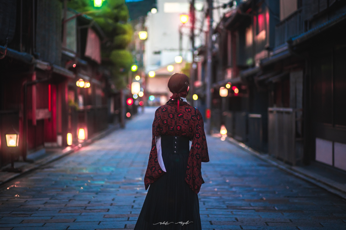 和装を着た女性のポートレート写真。背中を向けて歩いている。