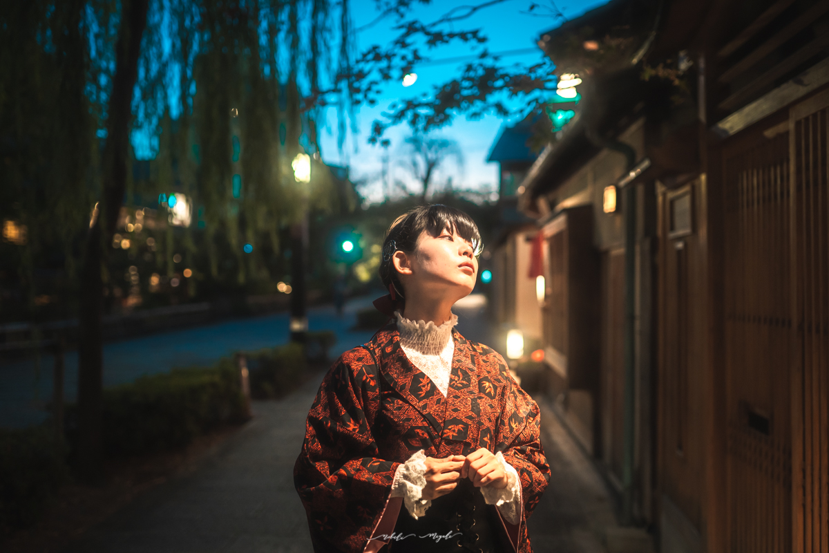 和装を着た女性のポートレート写真。街灯に顔を向けている。