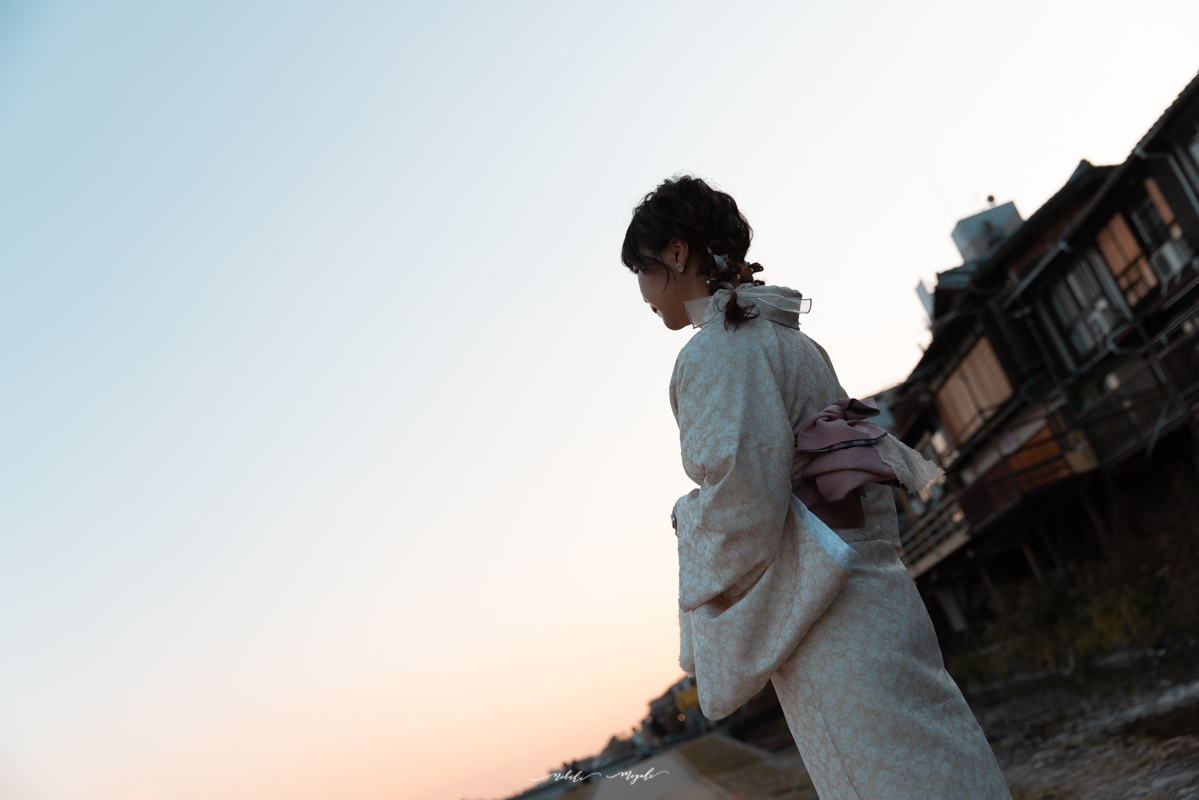 着物を着た女性のポートレート写真。鴨川周辺で撮影。夕日が見えている。