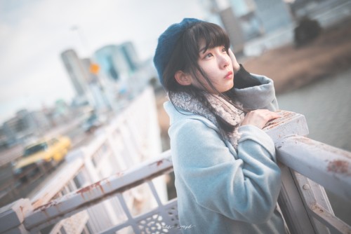 女性モデルの写真。橋の上で立っている。